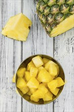 Sliced Pineapple on an old wooden table as detailed close-up shot, selective focus