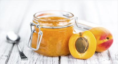 Apricot Jam on an old wooden table as detailed close-up shot (selective focus)