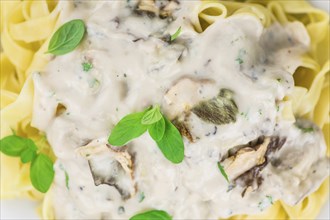 Porcini pasta as high detailed close-up shot on a vintage wooden table, selective focus