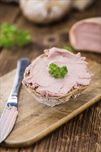 Homemade Liverwurst Sandwich on an wooden table (selective focus) as detailed close-up shot