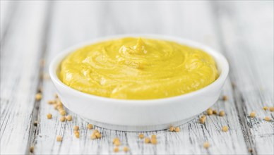 Portion of homemade Mustard on wooden background (selective focus, close-up shot)