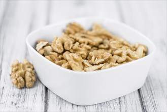 Walnuts (kernels) on an old wooden table as detailed close-up shot (selective focus)