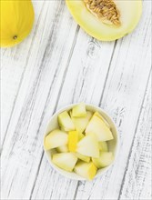 Fresh made Yellow Honeydew Melon on a vintage background (close-up shot)