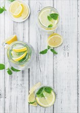 Homemade Lemonade on an wooden table (selective focus) as detailed close-up shot