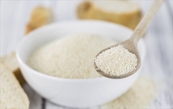 Some Bread Crumbs on a vintage wooden table (selective focus, close-up shot)