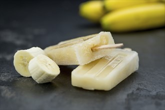 Homemade Banana Popsicles on a vintage background (close-up shot, selective focus)