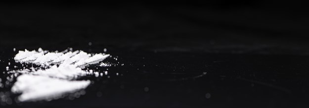 Dark plate with a portion of Cocaine as close-up shot