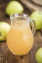 Homemade Apple Juice on an wooden table (selective focus) as detailed close-up shot