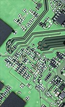 Green printed circuit board (PCB) close-up shot with a lot of electronic components