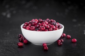 Portion of healthy Dried Cranberries on a slate slab (selective focus)