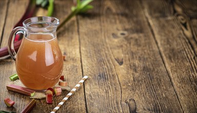 Rhubarb Juice on a rustic background (close up shot, selective focus)