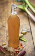 Old wooden table with fresh made Rhubarb Juice as detailed close up shot (selective focus)