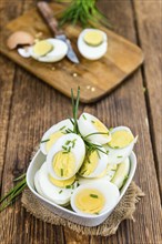 Halved Eggs on wooden background (close-up shot, selective focus)