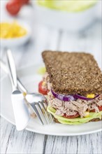 Old wooden table with Tuna sandwich (on wholemeal bread, selective focus)