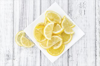 Homemade Lemon Slices on an wooden table (selective focus) as detailed close-up shot