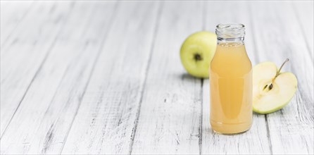 Homemade Apple Juice on an wooden table (selective focus) as detailed close-up shot