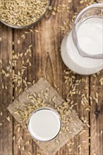 Healthy Oat Milk on a wooden table as detailed close-up shot (selective focus)