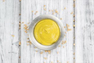 Portion of homemade Mustard on wooden background (selective focus, close-up shot)