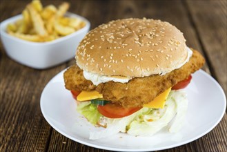 Homemade Fish Burger (close-up shot, selective focus) on a wooden table