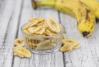 Dried Banana Chips on a vintage background as detailed close-up shot, selective focus