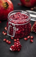 Portion of healthy preserved Pomegranate seeds on a slate slab (selective focus)