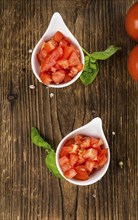 Diced Tomatoes on a vintage background as detailed close-up shot (selective focus)