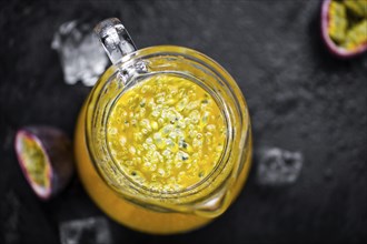 Portion of healthy Maracuja Juice on a slate slab (selective focus)