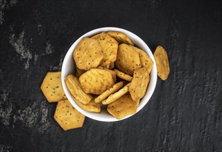 Portion of mixed Snacks on dark background (detailed close up shot, selective focus)