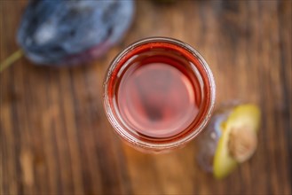 Fresh made Plum Liqueur on a vintage background as detailed close-up shot