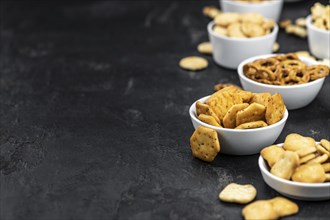 Portion of mixed Snacks on dark background (detailed close up shot, selective focus)