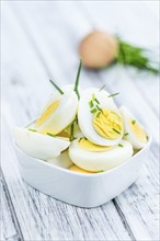 Halved Eggs on wooden background (close-up shot, selective focus)