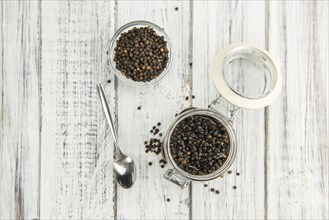 Black Peppercorns preserved on wooden background, selective focus, close-up shot