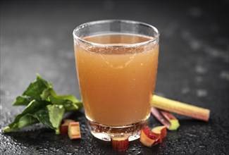 Rhubarb Juice on a rustic background (close up shot, selective focus)