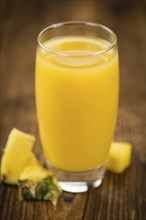 Fresh made Pineapple Juice on an old and rustic wooden table, selective focus, close-up shot