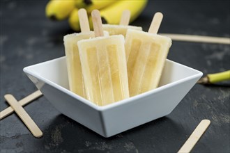 Banana Popsicles on a slate slab (selective focus, close-up shot)