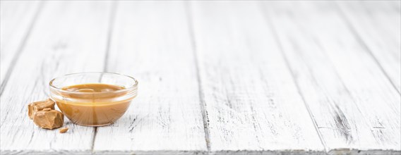 Portion of fresh Caramel Sauce (close-up shot, selective focus)