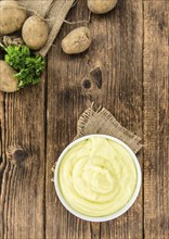 Portion of homemade Mashed Potatoes on wooden background (selective focus, close-up shot)