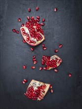 Portion of Pomegranate as detailed close up shot on a slate slab (selective focus)