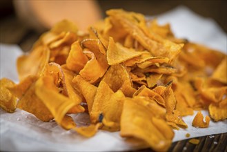 Homemade Sweet Potato Chips on vintage background selective focus, close-up shot