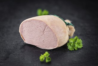 Portion of German Leberwurst as detailed close up shot on a slate slab (selective focus)