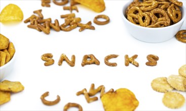 Portion of mixed Snacks isolated on white background (detailed close up shot, selective focus)