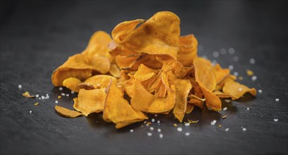 Some fresh Sweet Potato Chips on a vintage slate slab, selective focus, close-up shot