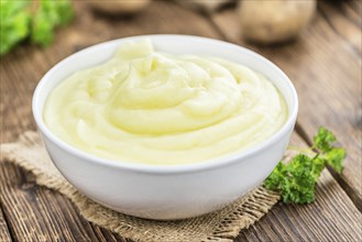 Potato Mash on rustic wooden background (close-up shot)