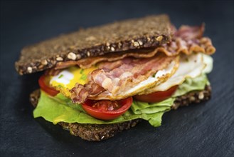 Slate slab with a Bacon and Egg Sandwich (close-up shot)