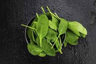 Vintage looking table with fresh Spinach (detailed close-up shot, selective focus)