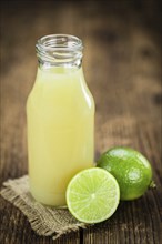 Fresh made Fresh Lime Juice on an old and rustic wooden table (selective focus, close-up shot)