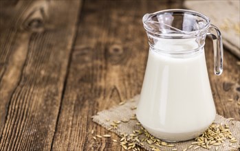 Wooden table with Oat Milk (detailed close-up shot, selective focus)