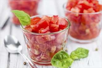 Tomatoes (diced) as high detailed close-up shot on a vintage wooden table (selective focus)