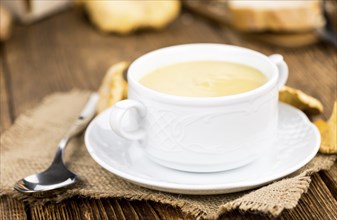 Creamy Chanterelle Soup on an old wooden table as detailed close-up shot, selective focus