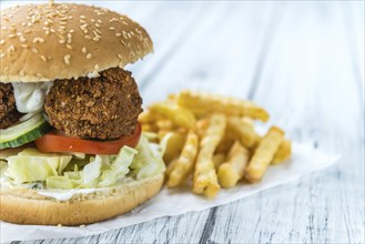 Wooden table with a homemade Falafel Burger (selective focus)